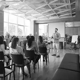 Egresado de la Maestría en psicología está dando su primera integración en una empresa, explica a parte del equipo los beneficios que conseguirán con su gestión.